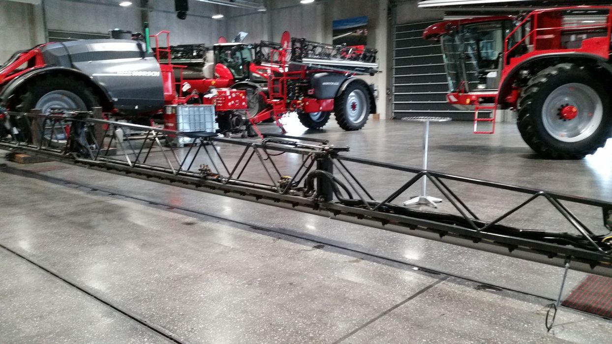 Mehrere große, rote Horsch-Landmaschinen in einer sauberen Industriehalle mit ausgeklapptem Spritzgestänge im Vordergrund.