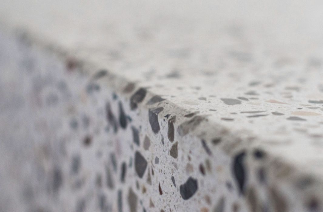 Nahaufnahme einer hellen Terrazzoplatte mit einer scharfen Kante, die in den Hintergrund unscharf verläuft.