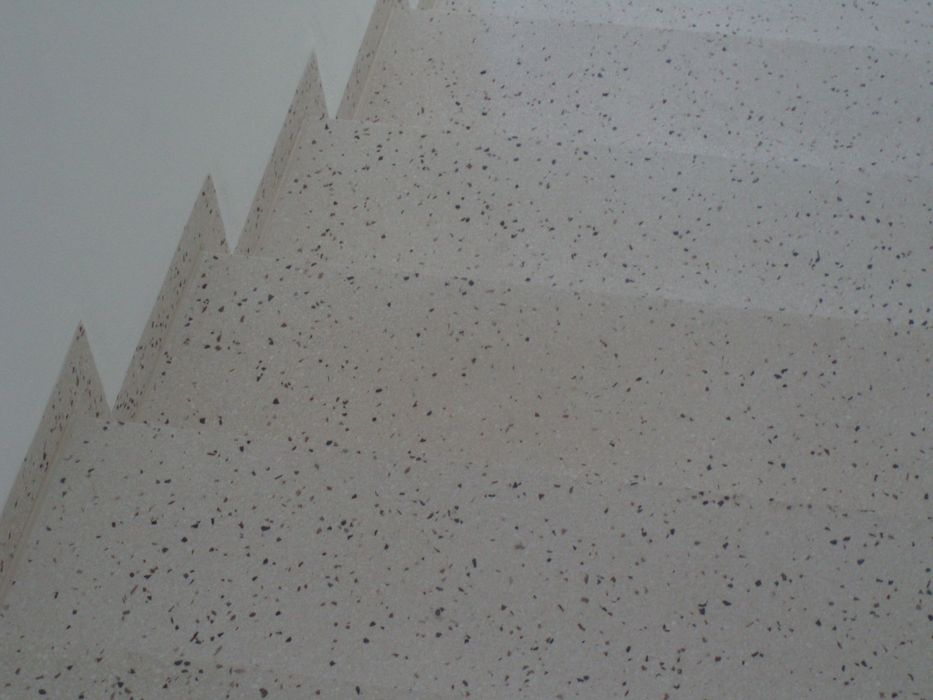 Die Perspektive von unten auf eine Treppe mit hellem, gesprenkeltem Steindesign.